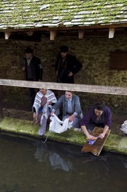 France, Eure, old wash-house of Sainte Colombe prés Vernon, Allied Reconstitution Group (US World War 2 and french Maquis historical reconstruction Association), the reenactors showing three women washing clothes in the washhouse in the 1940s and two partisans of the French Forces of the Interior (FFI) in the background