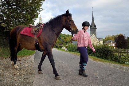 France, Calvados, Pays d'Auge, La Roque Baignard, young girl going out to ride