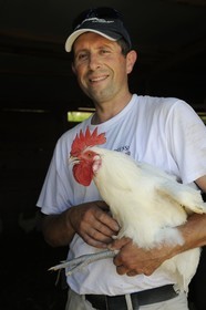 France, Saône et Loire (71), Sornay, Philippe Buatois, éleveur de volaille de Bresse, avec un coq pattes bleues