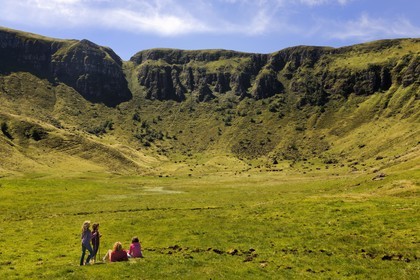France, Cantal, France, Cantal, monts du Cantal, Parc Naturel Régional des Volcans d'Auvergne (regional nature park of Auvergne volcanoes), Puy-Mary, family of hikers at the foot of the mountain of the Fours de Peyre Arse cut by the breach of Roland