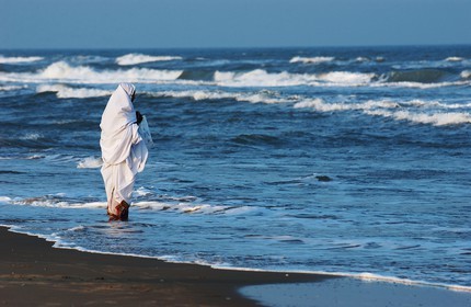 Inde, Territoire de Pondichéry, femme en tenue de deuil sur une plage de Pondichéry