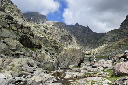 France, Alpes-Maritimes, parc national du Mercantour (Mercantour National Park), the Vallee des Merveilles (Valley of Wonders) scattered with thousands of rupestral engravings of the Bronze Age, hikers on the trail GR 52 at the Merveilles Lake below the Baisse (pass) de Valmasque and the Mont Grand Capelet (2915 m) in the background left