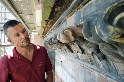 France, Bas-Rhin (67), Strasbourg, vieille ville classée au Patrimoine Mondial de l'UNESCO, la cathédrale Notre-Dame, chargé de la conservation à la Fondation de l'Oeuvre Notre-Dame et aussi restaurateur-tailleur de pierre, Mathieu Baud observe des traces de polychromie sur la frise végétale