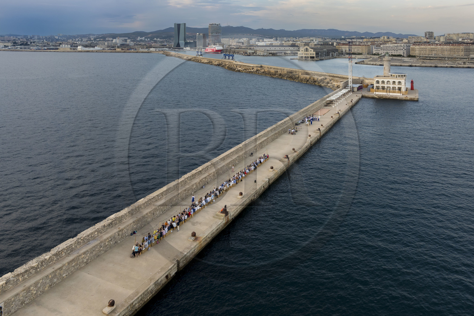France, Bouches-du-Rhône (13), Marseille, Zone Euroméditerranée, grand port maritime de Marseille (GPMM), la digue du large, convives attablés à une grand table de banquet dressée par le chef Emmanuel Perrodin dans le cadre des Diners Insolites, la tour CMA CGM et tour La Marseillaise en arrière plan (vue aérienne)
