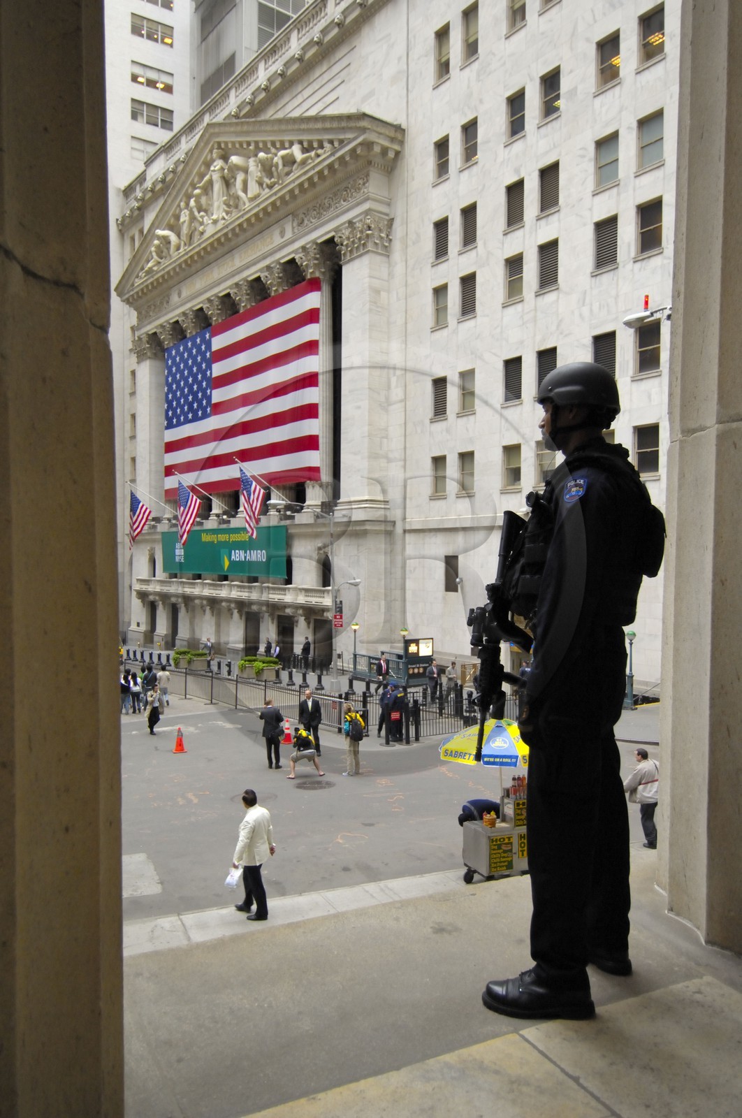 Etats-Unis, New York, Manhattan, policier lourdement armé montant la garde devant la bourse de Wall Street