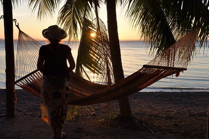 Nicaragua, Ometepe Island, sunset on a  Lake Nicaragua beach, woman in front of a hammock