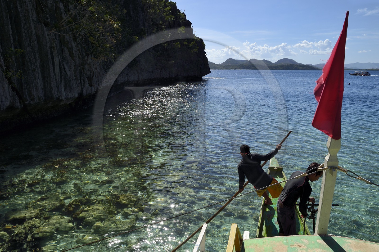 Philippines, Calamian Islands dans le nord de Palawan, Coron Island Natural Biotic Area, pirogue à balancier au pied des rochers de calcaire dans une petite crique