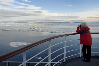 Groenland, cote Nord-Ouest, Smith sound au nord de la baie de Baffin, le bateau de croisière MS Fram de la compagnie Hurtigruten, passager observant la banquise et la côte canadienne de l'ile d'Ellesmere en arrière plan