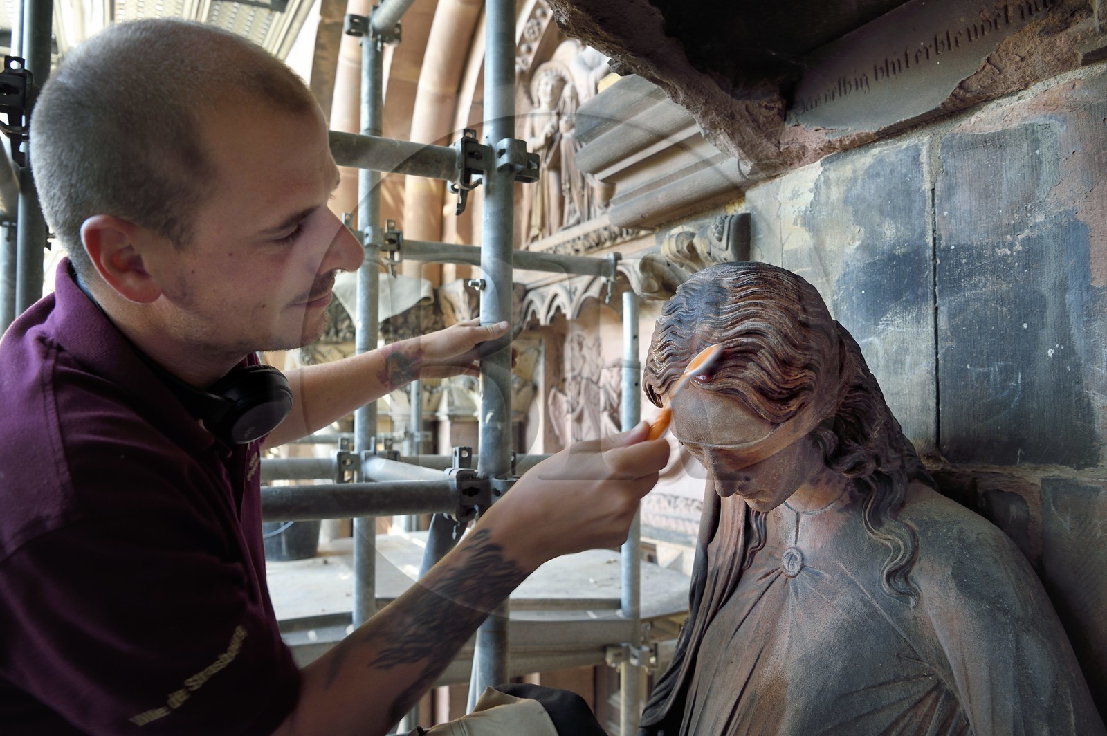 France, Bas-Rhin (67), Strasbourg, vieille ville classée au Patrimoine Mondial de l'UNESCO, la cathédrale Notre-Dame, chantier de restauration du Portail du Jour du jugement, nettoyage de la sculpture dite de la Synagogue à la brosse à dent par un compagnon tailleur de pierre