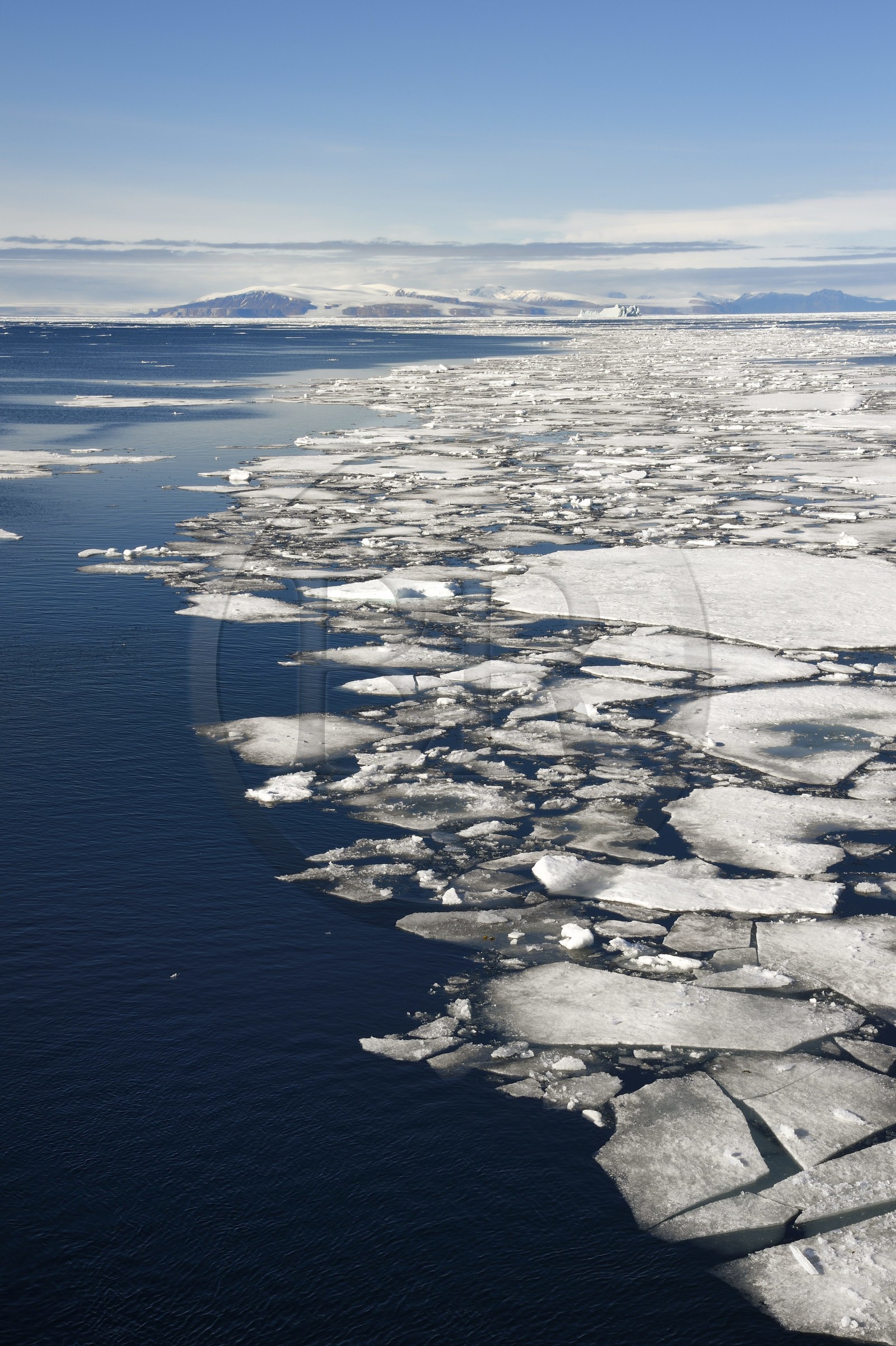 Groenland, cote Nord-Ouest, Smith sound au nord de la baie de Baffin, morceaux de glace de la banquise arctique et iceberg géant en arrière plan vers la côte canadienne de l'ile d'Ellesmere