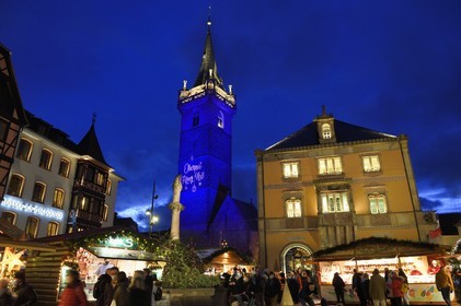 France, Bas Rhin, Obernai, Christmas market on the market square, Chapel Tower (Kappelturm) completed in the 16th century, serves as a belfry next to the town hall