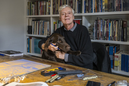 France, Paris (75), le dessinateur et auteur de bande-dessinée François Schuiten dans son atelier parisien, avec son chien Ulysse