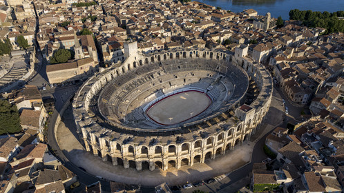 France, Bouches du Rhone, Arles, the Arena, a Roman amphitheater built around 80-90 AD, listed as World heritage by UNESCO, in the heart of the old town and the Rhone river in the background (aerial view)