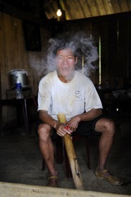 Vietnam, Lao Cai province, Sapa district, farmer from the Black Hmong minority group smoking the waterpipe bang