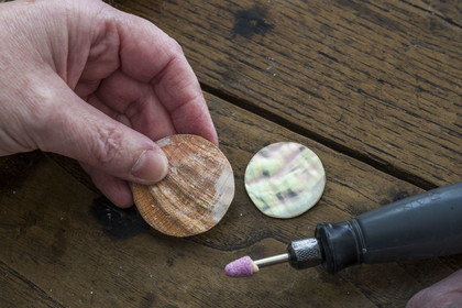France, Côtes-d'Armor, Tréguier, one of the Le Poupon sisters who are artisans of Art nacrier, works the mother-of-pearl of abalone shell in the Ys Paris creation workshop