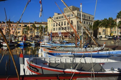 France, Var, Sanary-sur-Mer, traditional fishing boats called pointus in the port, Hotel de la Tour that wraps the Romanesque 13th century tower in the background