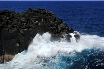 France, Ile de la Reunion, côte sud, Saint-Philippe, le Cap Méchant est situé le long d'une côte déchiquetée de roche volcanique frappée par la houle et typique de la région appelée Sud sauvage, pêcheur sur un rocher