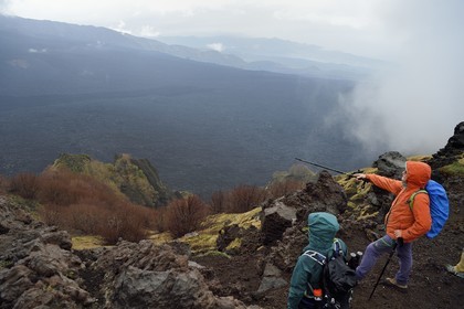 Italie, Sicile, Parc naturel régional de l’Etna, le Mont Etna, classé Patrimoine Mondial de l'UNESCO, randonneurs en bordure de la Valle del Bove qui correspond à un effondrement d’une des parois de l’Etna créant un champ de roches volcaniques de 7 km par 6 km