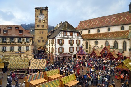 France, Haut Rhin, Strasbourg, Ribeauvillé, the medieval christmas market, medieval dances by members of La danserie des Ribeaupierre and in the background a stall offering wild boar on the spit on the square in front of the Augustinian convent church and the Tour des Bouchers (Butchers Tower)