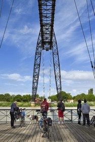 France, Charente-Maritime (17), Rochefort, le pont transbordeur de Rochefort (ou Martrou) construit par Ferdinand Arnodin en 1900, cycliste faisant la véloroute La Flow Vélo à bord de la nacelle en translation au dessus du fleuve Charente