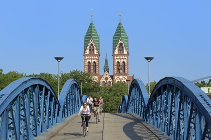 Allemagne, Bade-Wurtemberg, Fribourg en Brisgau, cycliste sur le pont bleu (pont Wiwili) et l'église du Sacré-Coeur de Jésus (Herz-Jesu-Kirche) en arrière-plan