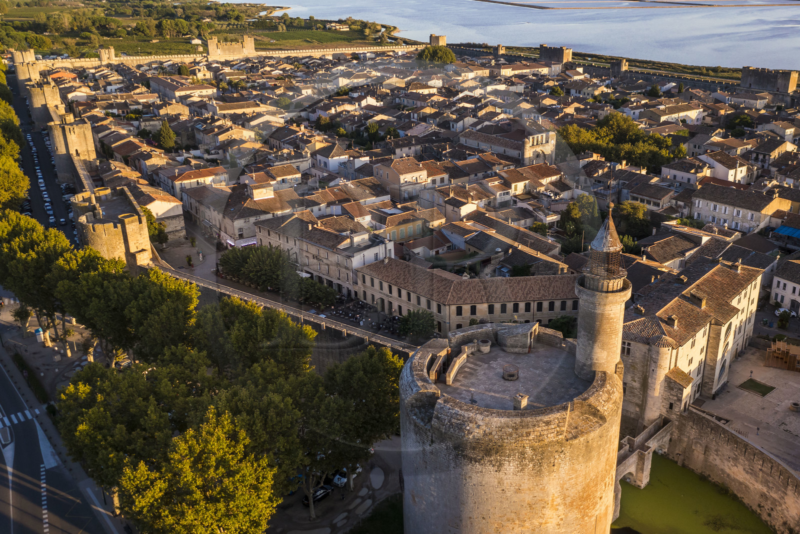 France, Gard, Aigues Mortes, the medieval town surrounded by its ramparts, the Tower of Constance in the foreground and the salt marshes (Salins du Midi) in the background (aerial view)