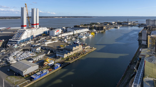 France, Loire-Atlantique (44), Saint-Nazaire, le chantier du super-yacht de luxe Ritz-Carlton Luminara dans la forme Joubert, les tours d'éoliennes à coté sont stockées avant embarquement (vue aérienne)