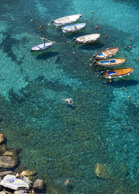Italy, Liguria, Cinque Terre National Park listed as World Heritage by UNESCO, boats and swimmers in the port of the village of Vernazza