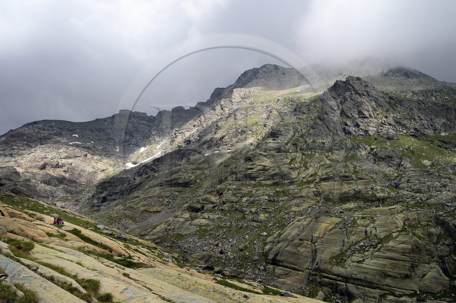 France, Alpes-Maritimes (06), parc national du Mercantour, Vallée des Merveilles parsemée de milliers de gravures rupestres de l'Age de bronze, randonneurs attroupés autour de la roche dite du Sorcier sur les dalles de schiste jaune des chiappes et le Mont Bégo en arrière plan