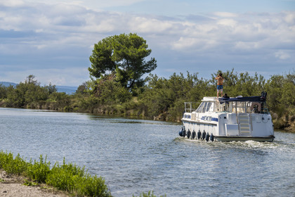 France, Hérault (34), La Grande-Motte, navigation d'un bateau de plaisance sur le canal du Rhône à Sète en bordure de l'étang de l'Or