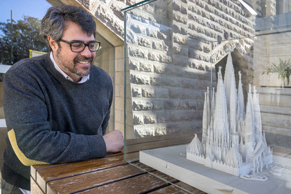 Espagne, Catalogne, Barcelone, quartier de l'Eixample, basilique de la Sagrada Familia de l'architecte du modernisme catalan Antoni Gaudi classée Patrimoine Mondial de l'UNESCO, Xisco Llabrès l'architecte en charge du chantier de la facade nord et du cloitre devant la maquette qui présente le cloitre terminé sous la facade de l'abside