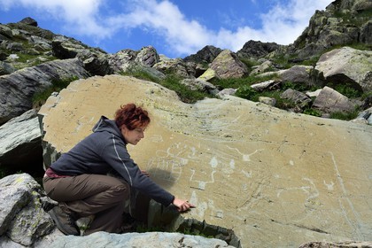 France, Alpes-Maritimes, parc national du Mercantour (Mercantour National Park), the Vallee des Merveilles (Valley of Wonders) scattered with thousands of rupestral engravings of the Bronze Age, the archaeologist Nicoletta Bianchi studies the Roche de l’Eclat engraved with hornlike figures, daggers and a large checkerboard-like figure that could symbolize cultivated fields