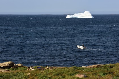Groenland, cote ouest, baie de Baffin, Upernavik, départ en barque pour la chasse et iceberg en arrière plan