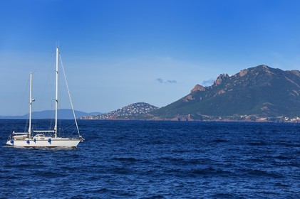 France, Alpes-Maritimes, sailboat off the Lerins Islands and the Esterel Mountains in the background