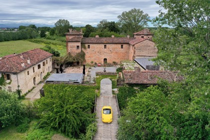 Italy, Emilia Romagna, Polesine Zibello near Parma, Antica Corte Pallavicina Hotel and restaurant, Alfa Romeo Duetto Spider yellow cabriolet (aerial view)