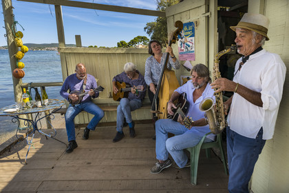 France, Hérault (34), Sète,  Pointe du Barrou sur les rives de l'étang de Thau, le groupe de musique Au Bois de mon cœur qui réinterprète les chansons de Georges Brassens, il est mené par le pêcheur sétois Jean-Louis Lambert au chant et à la guitare, Georges Cabaret à la guitare solo, Guy Blanc dit Guet au saxo alto, Denis Benito à la mandoline bluegrass et Tatiana à la contrebasse