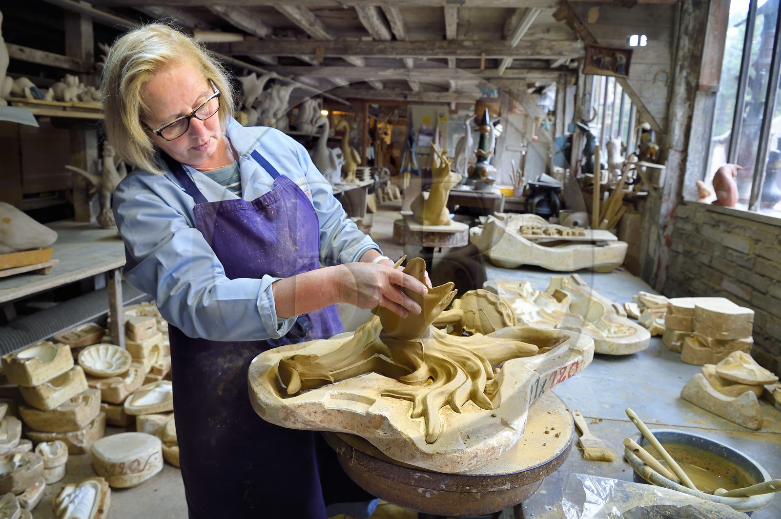 France, Calvados (14), Pays d'Auge, Bavent, poterie du Mesnil de Bavent, la céramiste Annie Richier au démoulage et finition d'un épi de faitage représentant un coq dans l'atelier