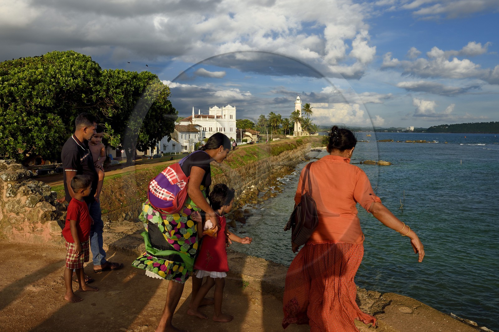Sri Lanka, Province du Sud, Fort de Galle, classé Patrimoine Mondial de l'UNESCO, famille sur les remparts maritimes de la ville fortifiée, la mosquée Meera et le phare en arrière plan