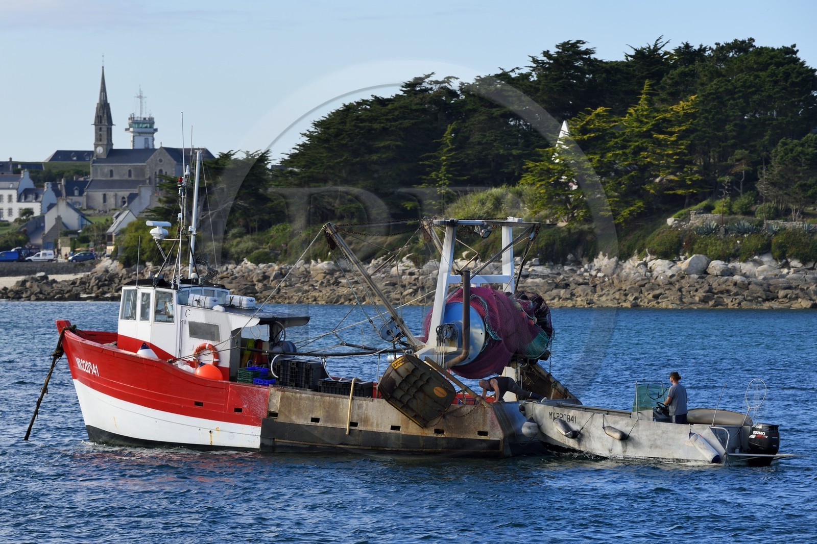 France, Finistere, Ile de Batz, fishing boat in Porz Kernok and Notre Dame du Bon Secours church