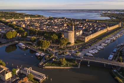 France, Gard (30), Aigues-Mortes, la ville médiévale entourée par ses remparts, la Tour de Constance et le port du canal du Rhône à Sète au premier plan, les marais salants (Salins du Midi) en arrière plan (vue aérienne)