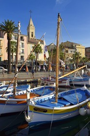 France, Var, Sanary-sur-Mer, traditional fishing boats called pointus in the port and St. Nazaire Church