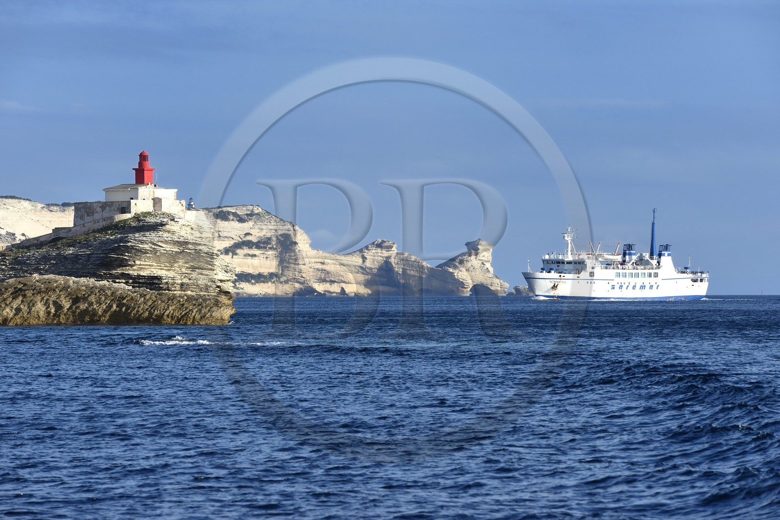 France, Corse-du-Sud (2A), Bonifacio, arrivée du ferry de liaison avec la Sardaigne au pied des falaises de calcaire et le phare à l'entrée de la calanque