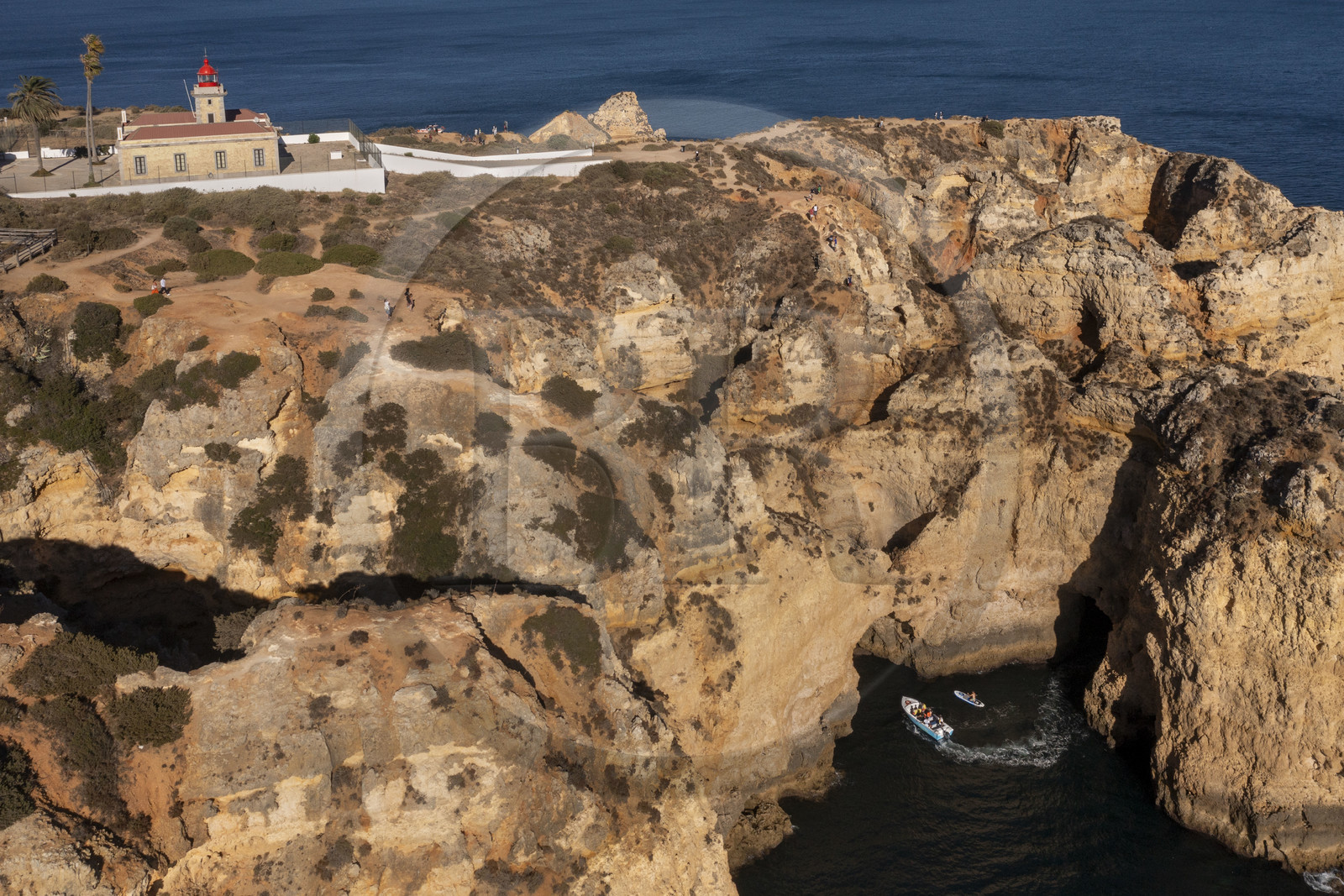 Portugal, Algarve, Lagos, phare à la pointe de Ponta da Piedade, découverte à pied, en bateau et en stand up paddle des grottes dans les falaises escarpées (vue aérienne)