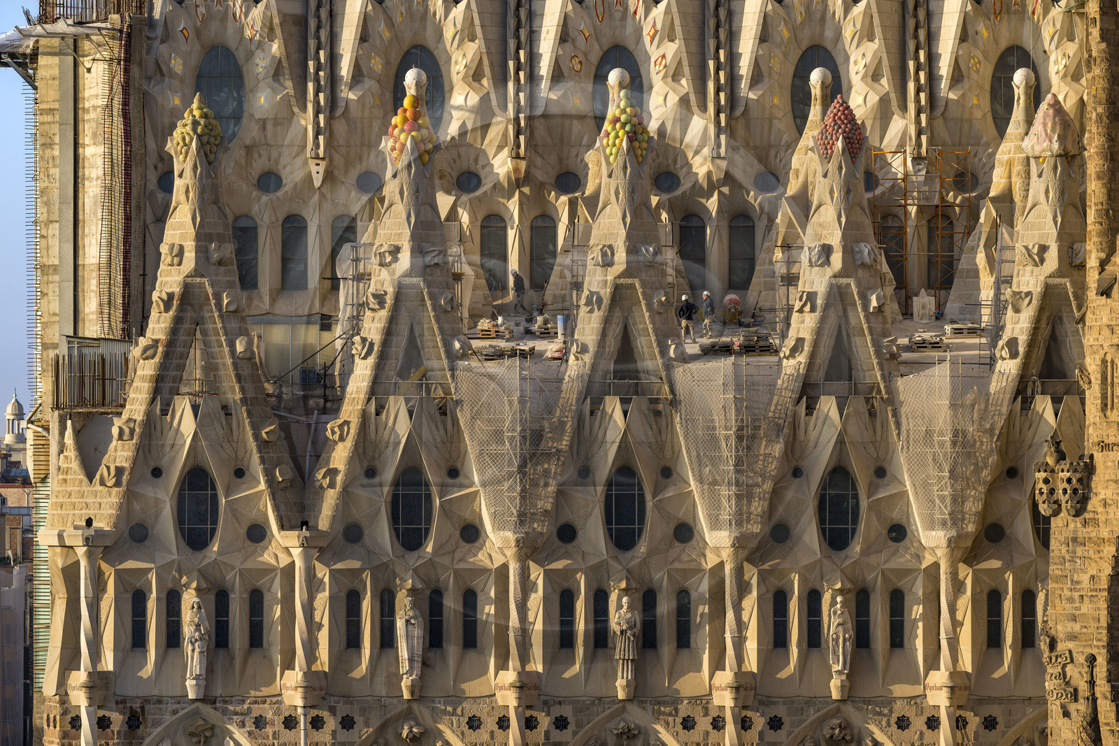 Espagne, Catalogne, Barcelone, quartier de l'Eixample, basilique de la Sagrada Familia de l'architecte du modernisme catalan Antoni Gaudi classée Patrimoine Mondial de l'UNESCO, sommets surmontés de mosaïques en forme de fruits entourant le chantier sur le toit de la nef ici côté facade de la Passion