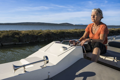 France, Hérault (34), Vic-La-Gardiole, la journaliste Pascale Desclos à la barre du bateau de plaisance Le Boat sur le canal du Rhône à Sète