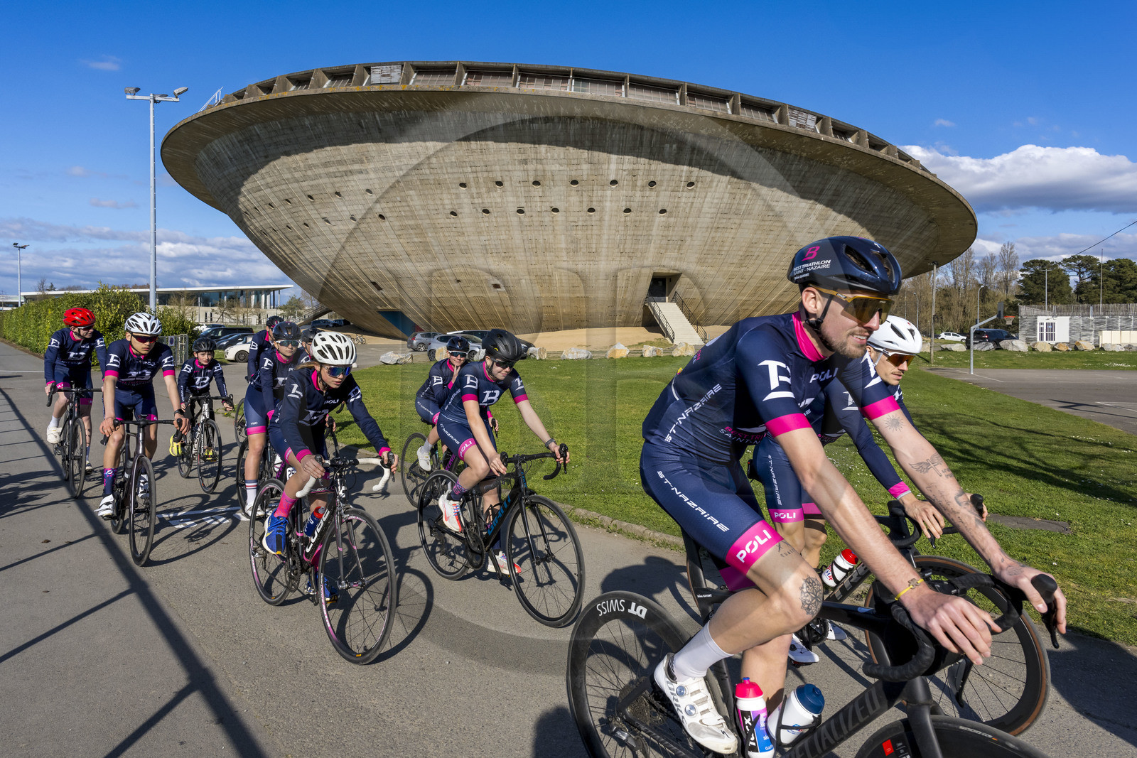 France, Loire-Atlantique (44), Saint-Nazaire, le Palais des sports appelé La Soucoupe datant de la reconstruction de la ville et des cyclistes du club Best Triathlon Saint Nazaire à l'entrainement