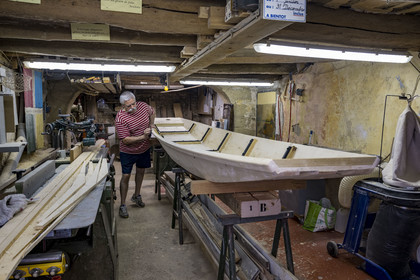 France, Vaucluse (84), L'Isle-sur-la-Sorgue, Alain Pretot, membre de la confrérie des pêcheurs les Pescaïres de la Sorgue, terminant la fabrication d'une barque à fond plat en épicéa appelée Nègo Chin dans son atelier