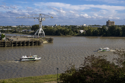 France, Loire-Atlantique (44), Nantes, Ile de Nantes, le Navibus passant devant le Hangar à Bananes sur les quais de Loire, la Grue Titan grise et la Maison Radieuse de Le Corbusier en arrière plan, vue depuis les hauteurs de Chantenay