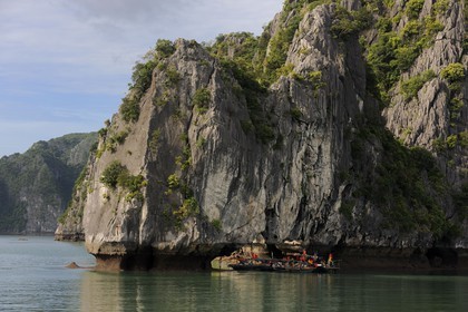 Vietnam, Quang Ninh Province, Halong Bay, listed as World Heritage by UNESCO, fishing boats under a naturel  limestone arch