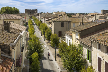 France, Gard (30), Aigues-Mortes, le boulevard Gambetta dans la vieille ville depuis les remparts et la Tour de la Porte de la Marine en arrière plan